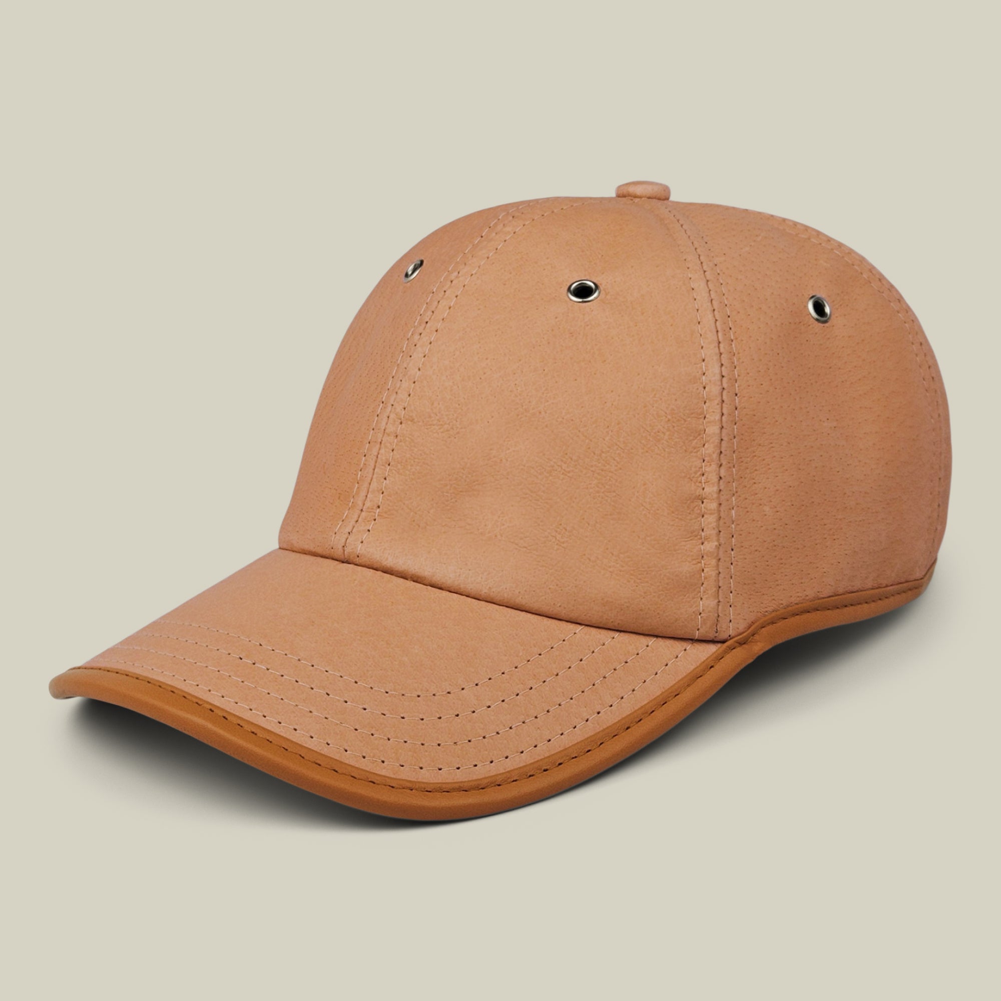 A tan Steiner papa cap by Goorin Bros. with visible stitching, metal eyelets, and a curved brim is set against a light beige background; it features an adjustable plaid strap for a comfortable fit.