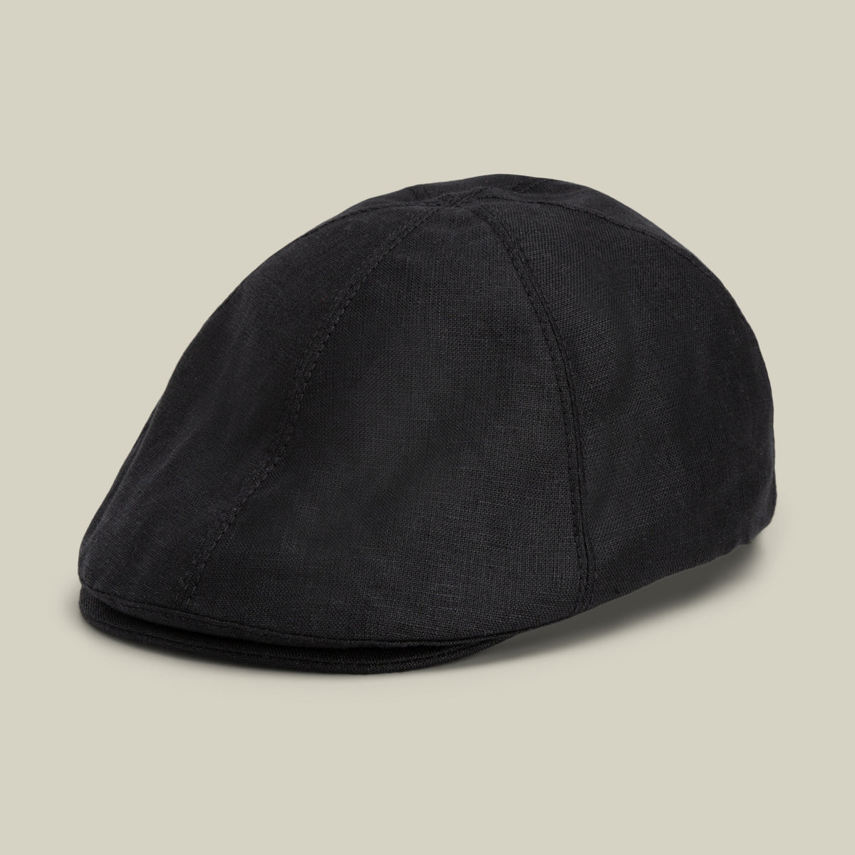 An ebony “Benjamin Paul” flat cap by Goorin Bros., crafted from fabric and ideal for everyday wear, displayed on a plain light beige background.
