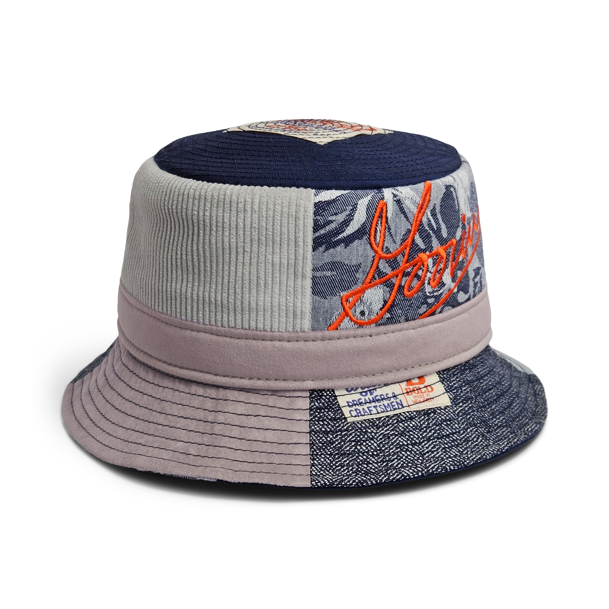 The Goorin Bros. Goorin Rework Bucket is a patchwork hat made from recycled materials in blue, gray, and mauve, featuring orange embroidery and stitched label details.