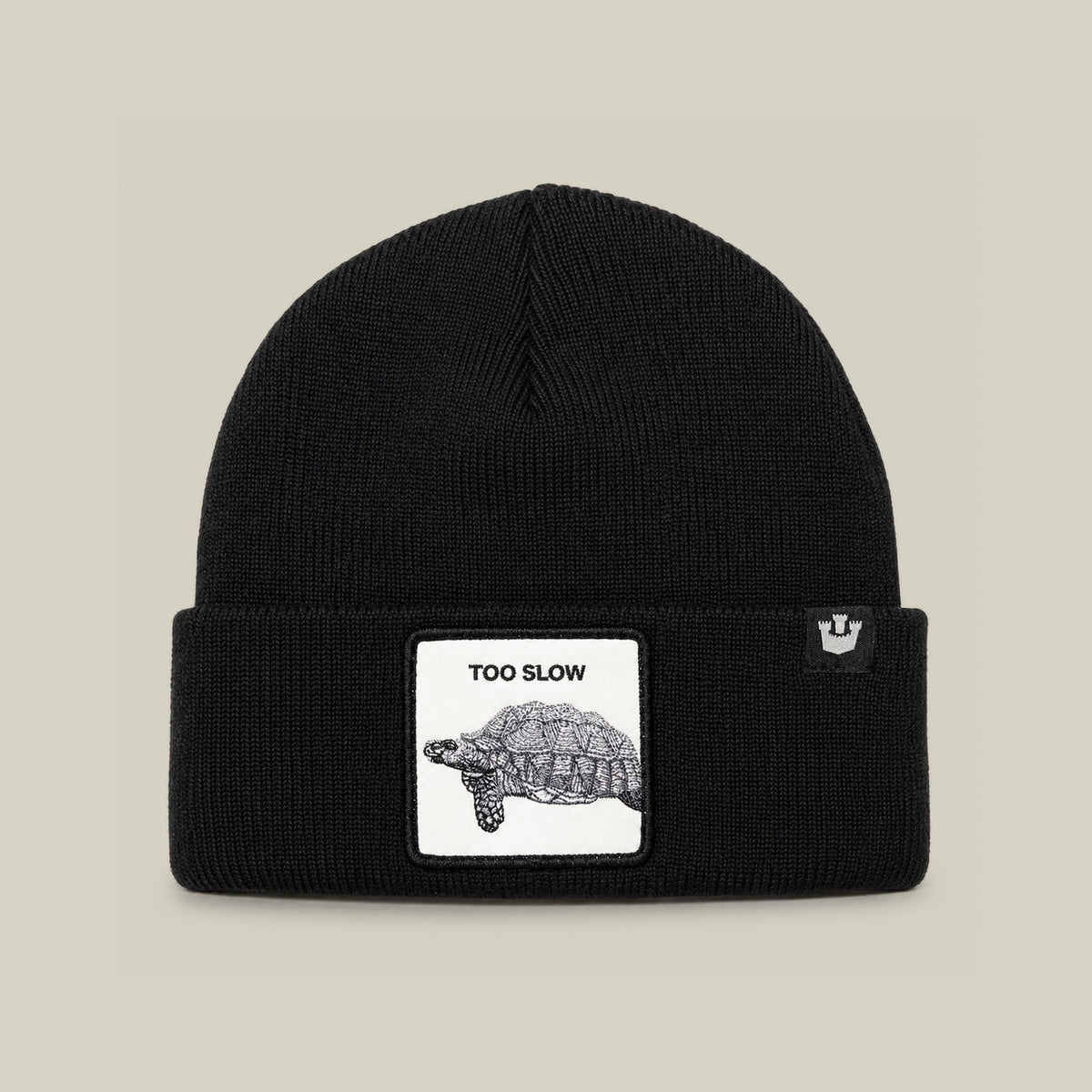 The Goorin Bros. Darn Low is a black knit beanie cap featuring a centered patch on the folded brim, with a tortoise illustration and the words “TOO SLOW” above it—an elusive drop and a true badge of honor for your collection.