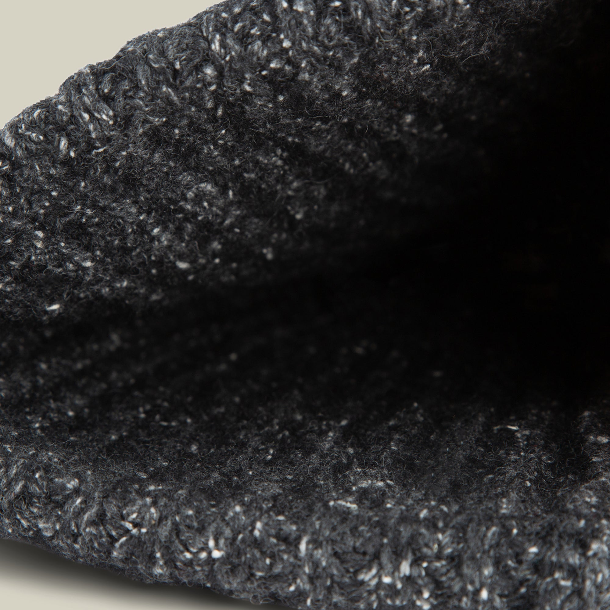 Close-up view of the opening of the textured, dark gray Northstar knitted fabric by Goorin Bros., possibly a beanie or sleeve.