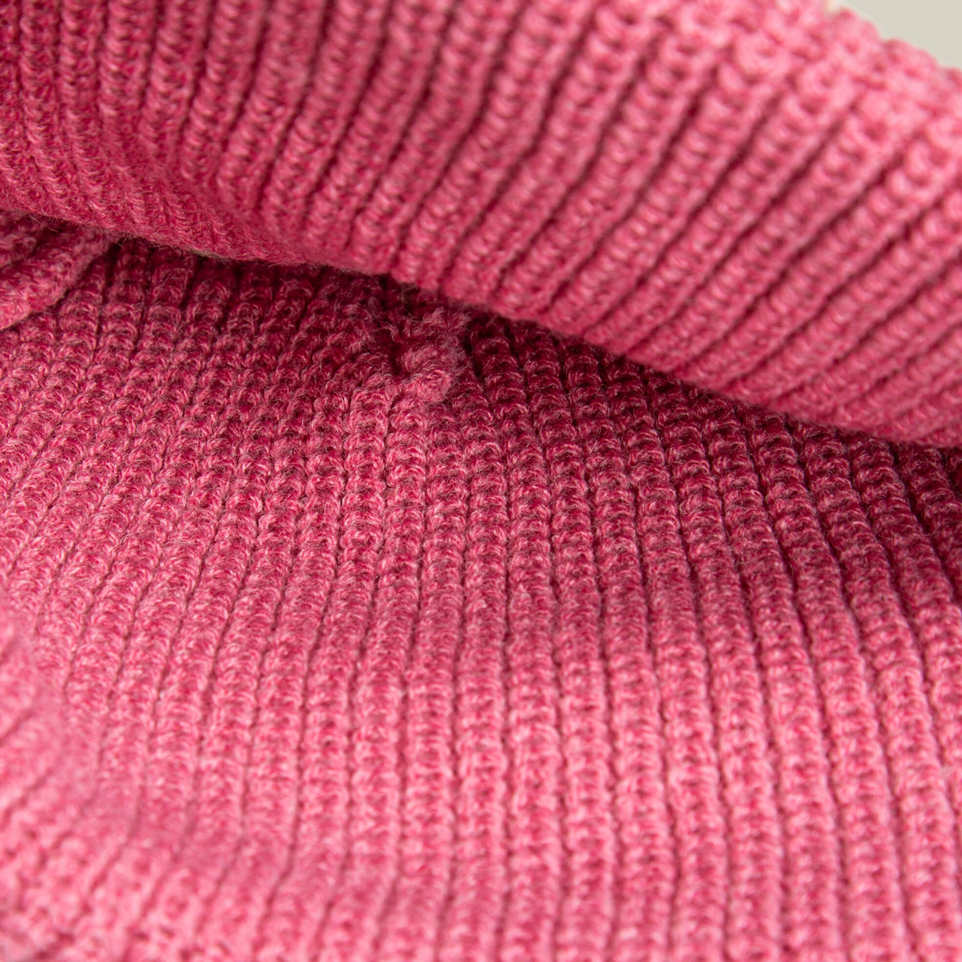A close-up of The Busy Beanie by Goorin Bros. highlights its cozy, pop-pink knit texture.