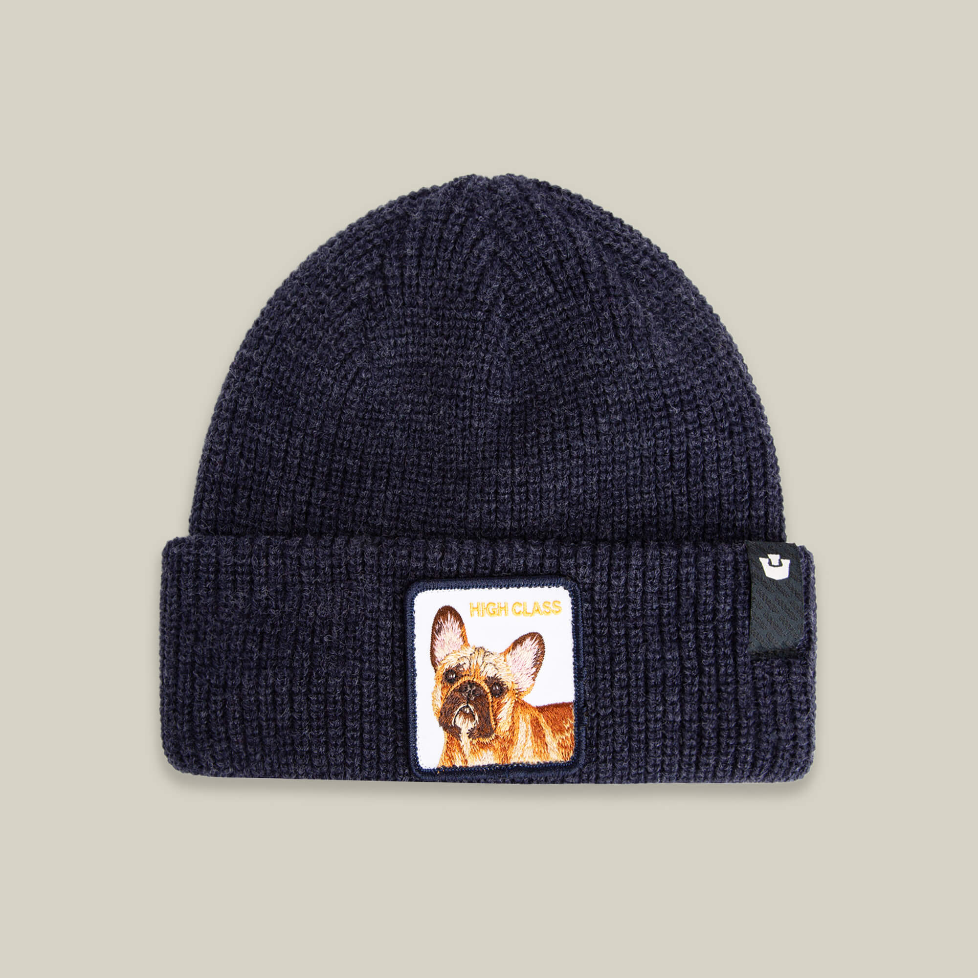 The High Class Beanie by Goorin Bros. in GALACTIC features a front cuff patch with a French bulldog and HIGH CLASS text—adding warmth, style, and personality to your winter look.