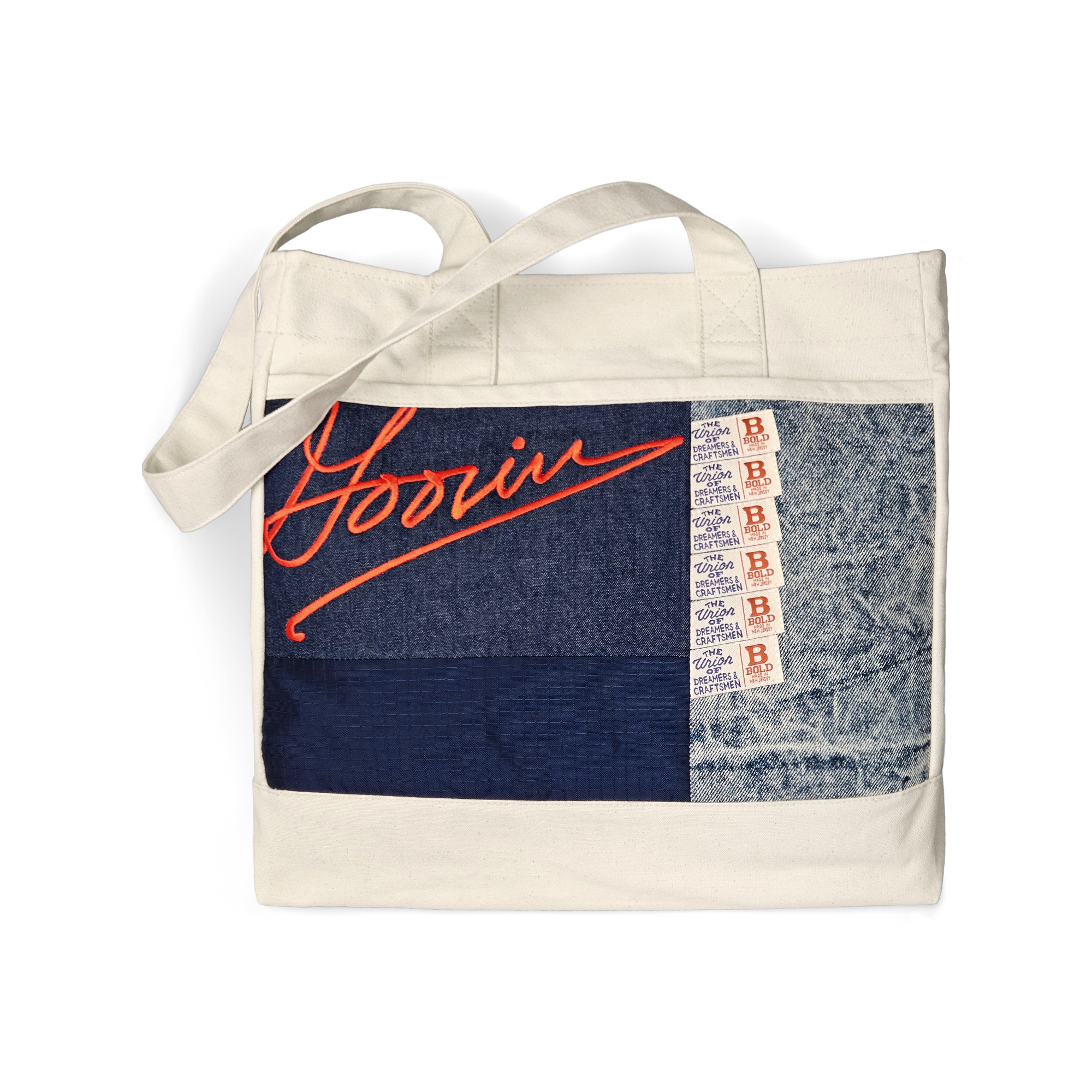 The Goorin Bros. Goorin Rework Tote in EDGE is a USA-made bag with a patchwork design, blue denim, red Goorin script, and vintage ticket strip detailing on the front.