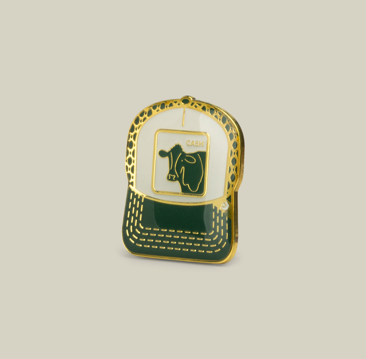The Cash Cow Trucker Pin by Goorin Bros. in Dust is a gold and green hat-shaped pin with a cow’s head design and “CASK”—perfect for collectors.