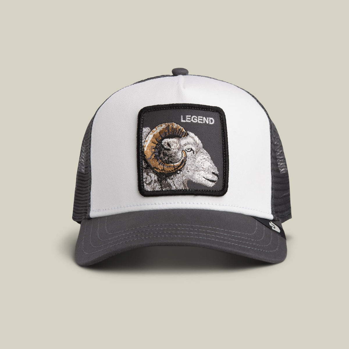 The Goorin Bros. Legend Trucker Mini is a white and charcoal mesh trucker hat with an embroidered ram head patch labeled "Legend" on the front, shown against a neutral background.