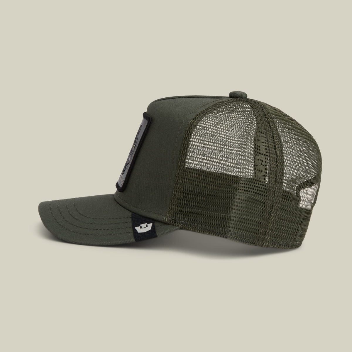 The Goorin Bros. Panther Trucker Mini is an olive green mesh trucker cap with a solid front panel, adjustable snapback closure, and a small branded patch on the side strap, shown in a studio product shot.