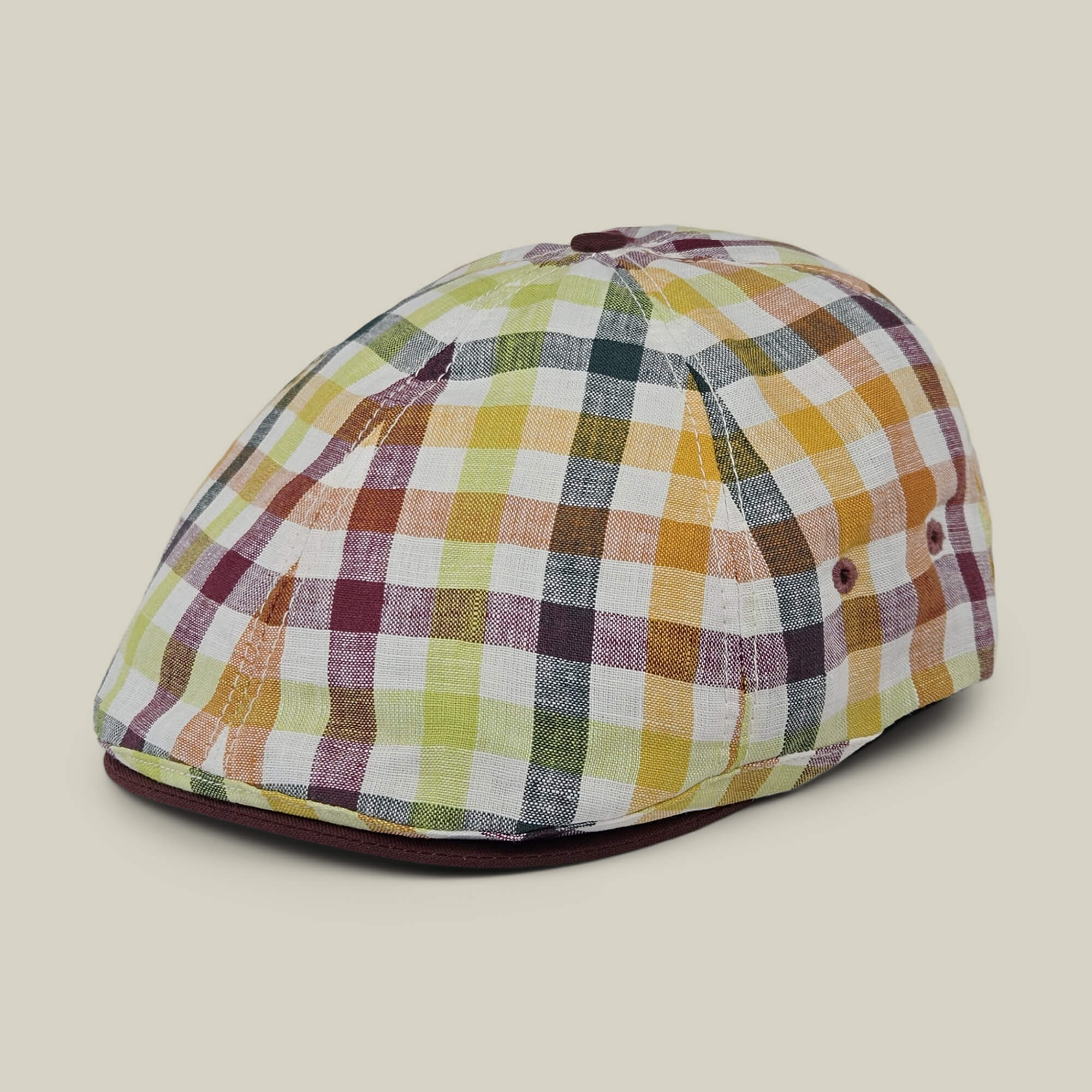 The Goorin Bros. Point Lobos is a 6-panel Ivy flat cap featuring a multicolored plaid pattern in shades of yellow, orange, green, and burgundy. Handmade in the USA from a breathable cotton blend, this stylish cap is showcased against a plain beige background.