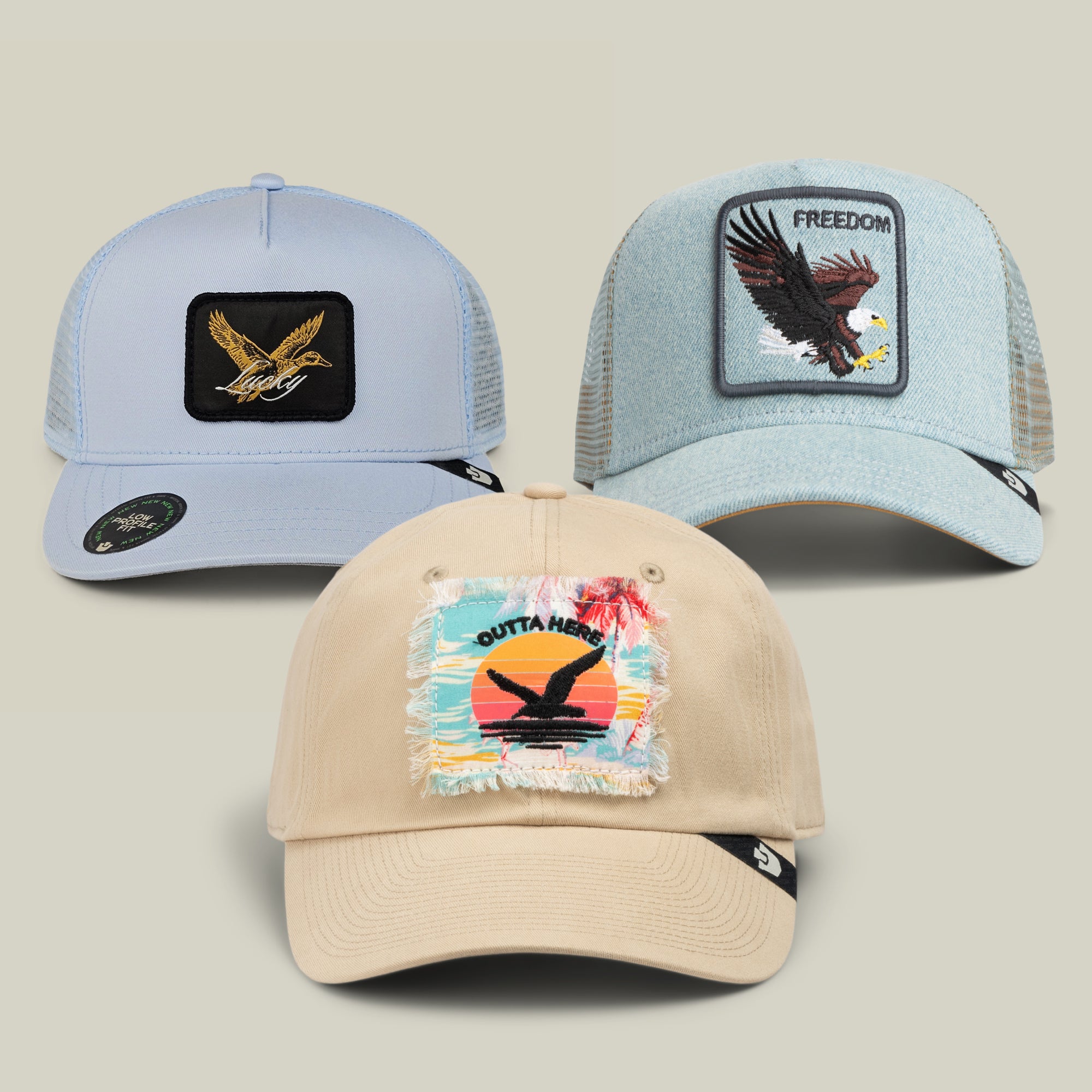 Three eagle-themed baseball caps from the Goorin Bros. Birdwatchers Club Bundle are displayed against a neutral background. The collection includes light blue, denim blue, and beige hats, each showcasing a unique eagle patch on the front. One cap stands out with its classic freedom style and distinctive checkered brim, enhancing the bold patriotic charm of the bundle.