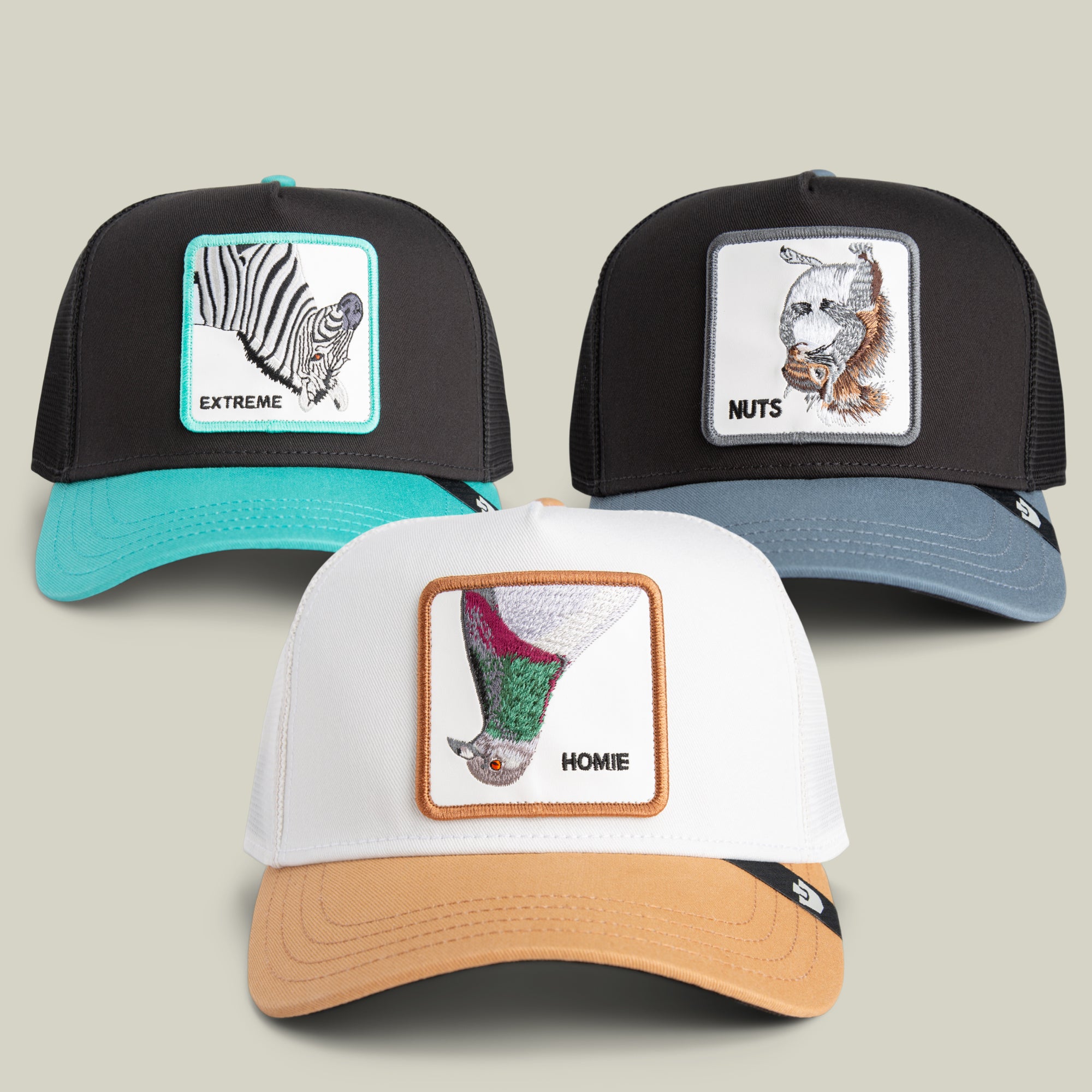 The Goorin Bros. Eldnub Bundle features three trucker hats with embroidered animal patches—a zebra labeled EXTREME, a squirrel labeled NUTS, and a bat labeled HOMIE—each set against a neutral background, with the bold zebra patch injecting an extra dose of wild style.