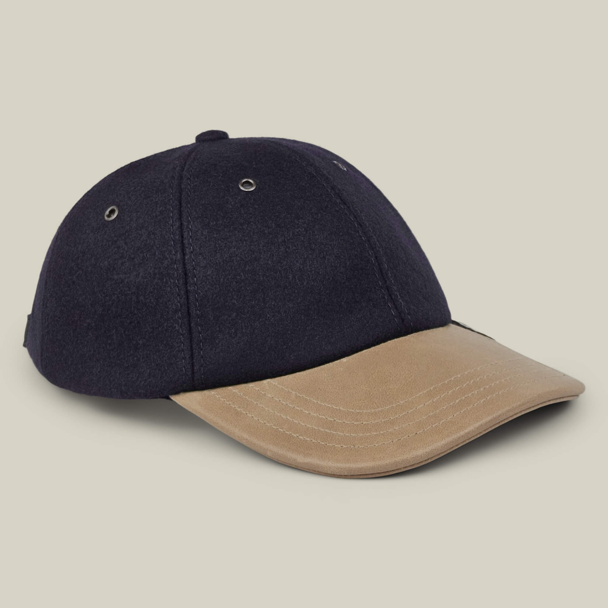Introducing the Bixby by Goorin Bros.: a black baseball cap with a beige curved brim, accented by silver eyelets and visible stitching, meticulously handmade in New Jersey and showcased against a clean, light background.