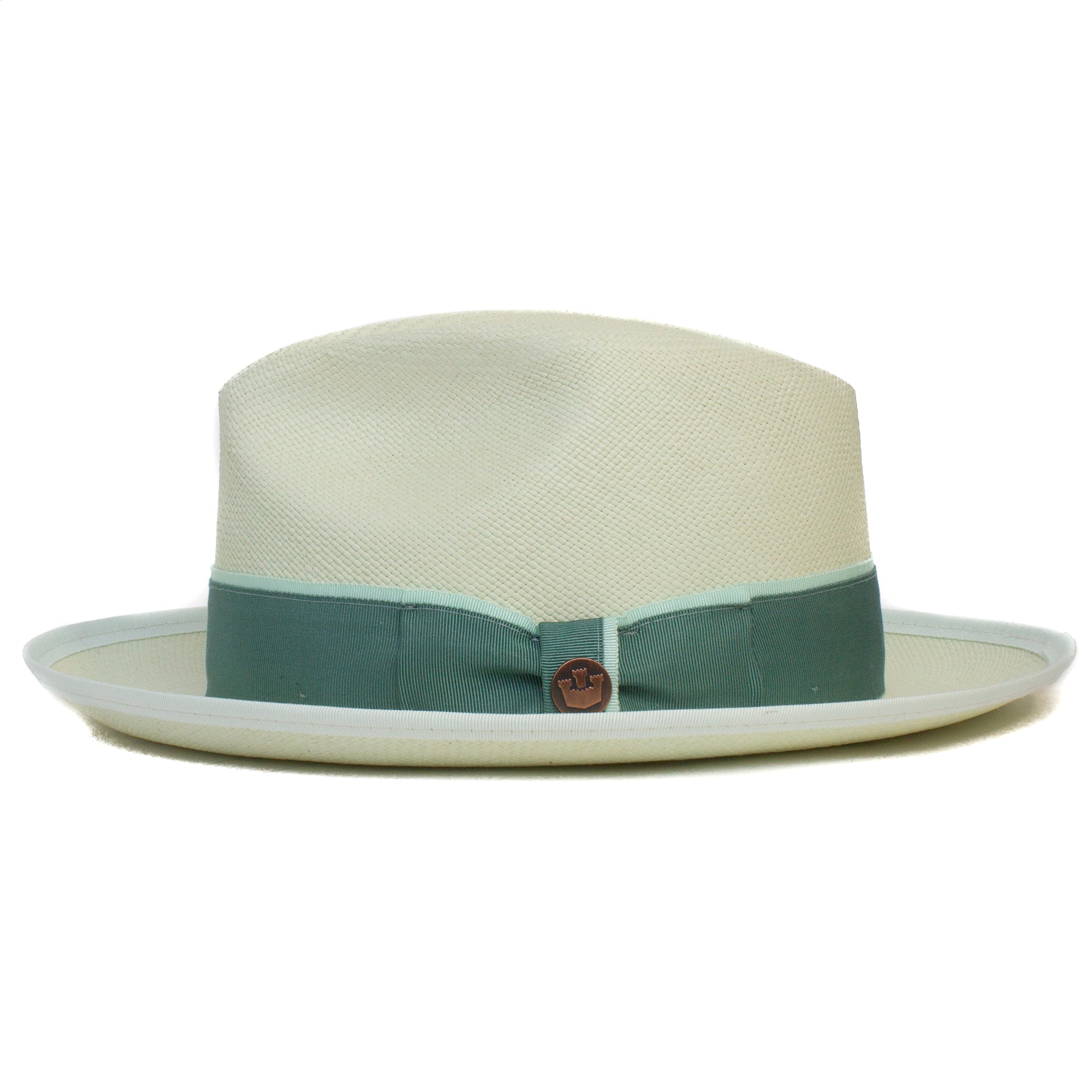 The Hartman by Goorin Bros. is a cream fedora with a wide green grosgrain band and a round brown emblem, shown on a white background. Offers 50 UPF sun protection for style and safety.