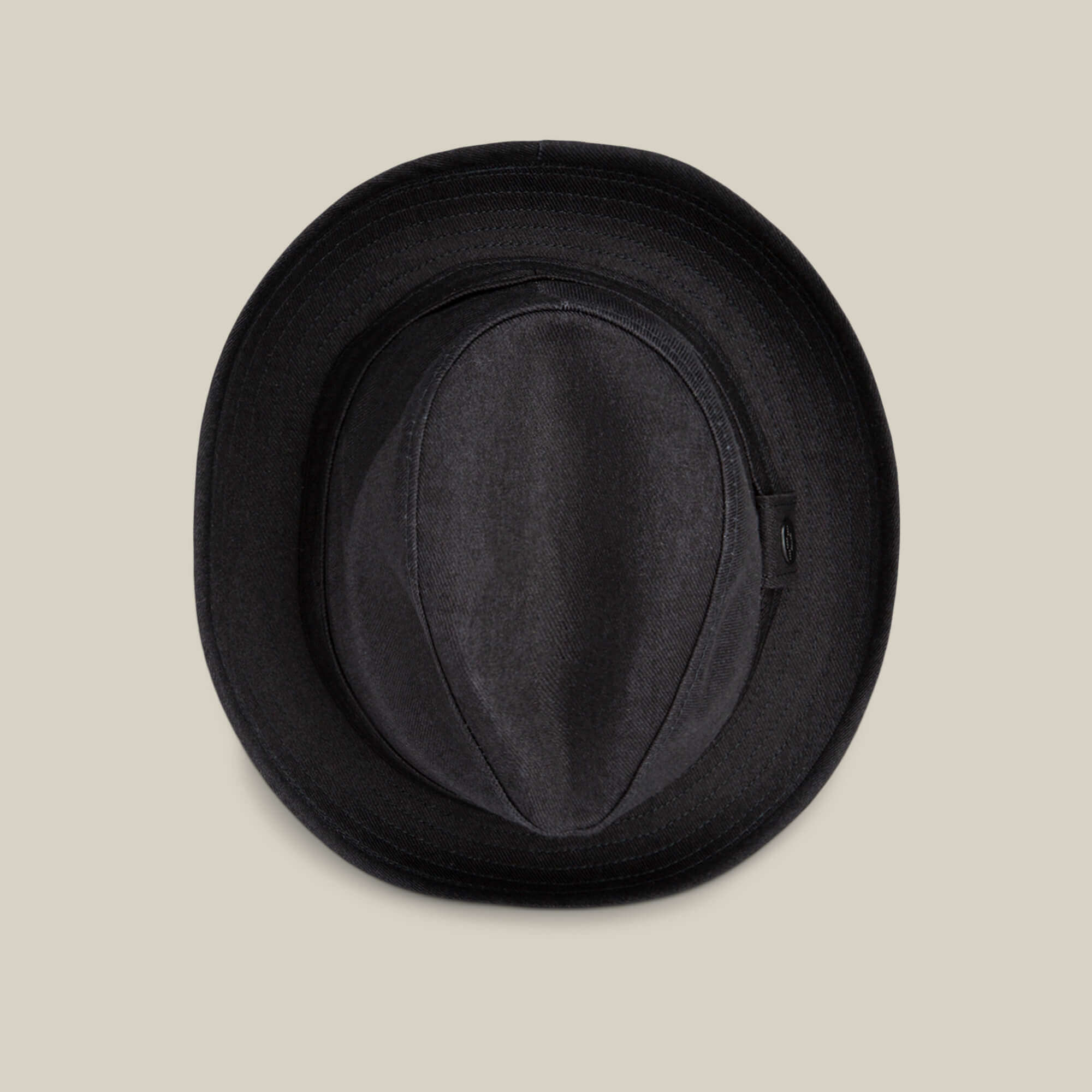 The Big Stepper by Goorin Bros., a black fedora hat and timeless accessory, is shown from above on a plain beige background.