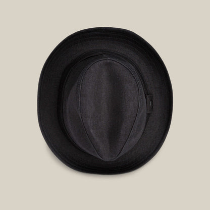 The Big Stepper by Goorin Bros., a black fedora hat and timeless accessory, is shown from above on a plain beige background.