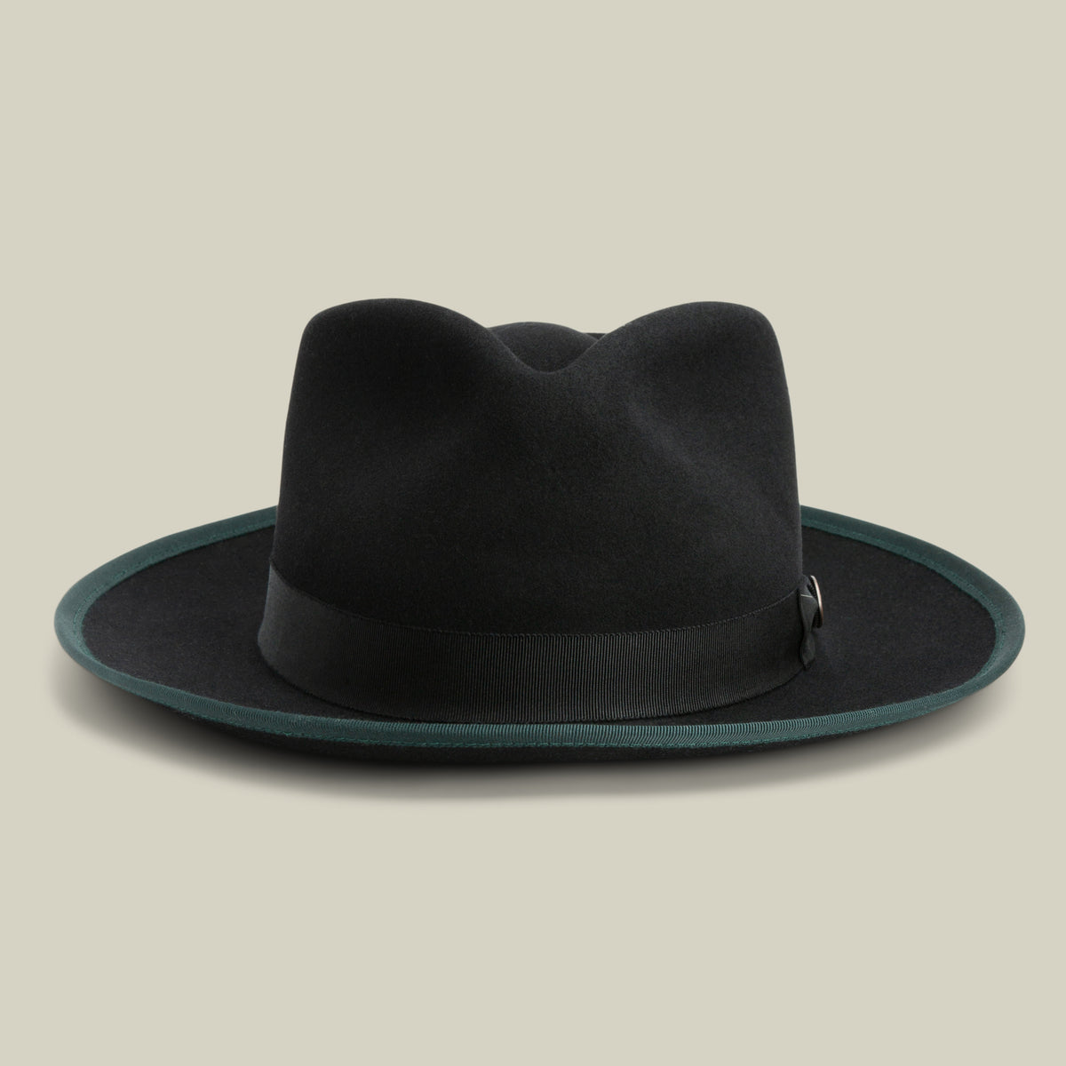 River Gray by Goorin Bros. is a black wide brim fedora crafted from premium merino wool, featuring a dark green edge trim and a black ribbon band. Set against a plain beige background, this American-made hat offers timeless style with exceptional craftsmanship.