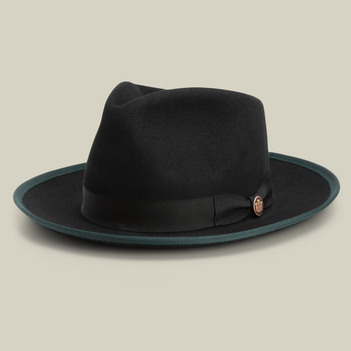 The Goorin Bros. River Gray is a black merino wool fedora hat featuring a wide brim with a dark green edge, a black ribbon band, and a small round pin, showcased against a plain light background.