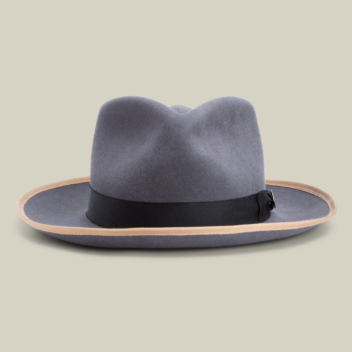 The River Gray fedora by Goorin Bros. features soft gray merino wool, a black ribbon band, and a light brown edge on the wide brim, set against a plain beige background. Crafted in America, this hat seamlessly blends timeless style with exceptional quality.