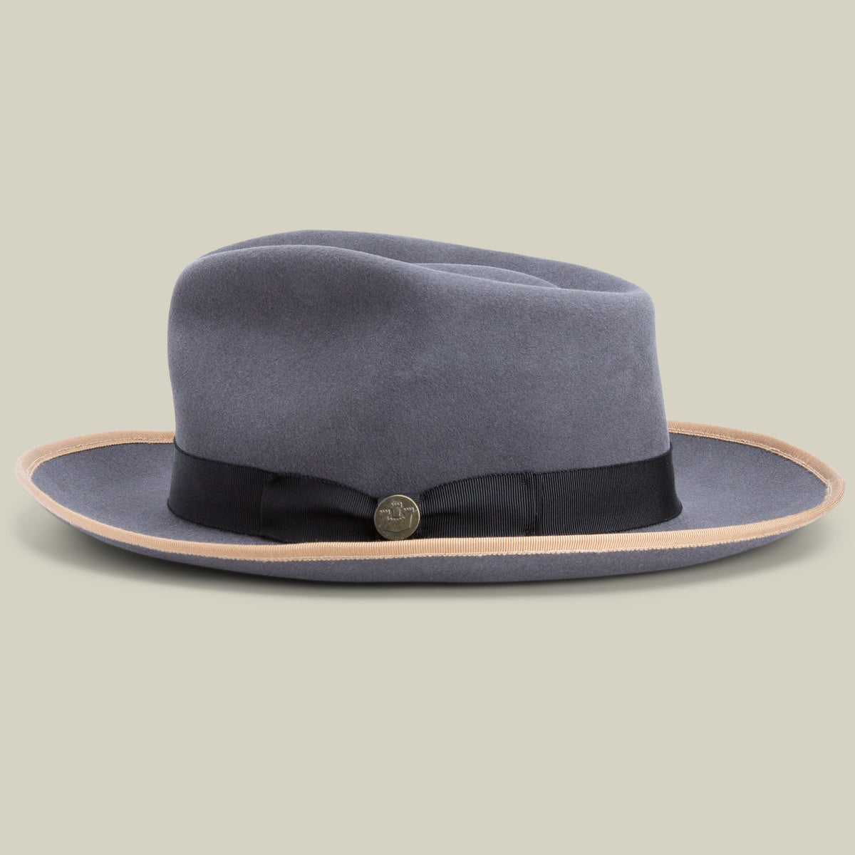 The River Gray by Goorin Bros. is a gray merino wool fedora featuring a wide brim, accented with a black ribbon band and a round metallic pin, shown on a neutral background. This classic American-made fedora offers enduring style and quality.
