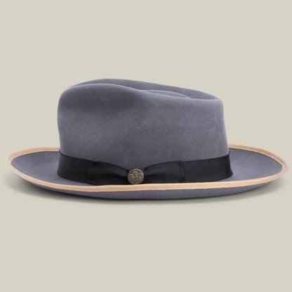 The River Gray by Goorin Bros. is a gray merino wool fedora featuring a wide brim, accented with a black ribbon band and a round metallic pin, shown on a neutral background. This classic American-made fedora offers enduring style and quality.