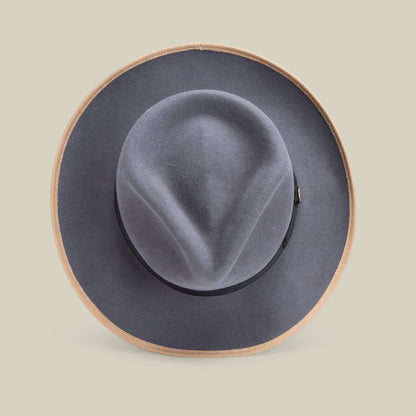 The River Gray by Goorin Bros. is a wide-brimmed hat, crafted from premium merino wool with a tan edge, displayed against a plain light background and viewed from above. Made in America, this fedora blends timeless style with exceptional craftsmanship.