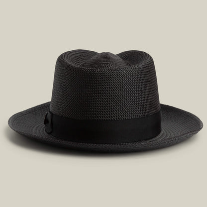The John Sr. by Goorin Bros. is a black toquilla teardrop fedora hat with a wide brim and black ribbon band, offering 50 UPF sun protection, displayed on a neutral background.