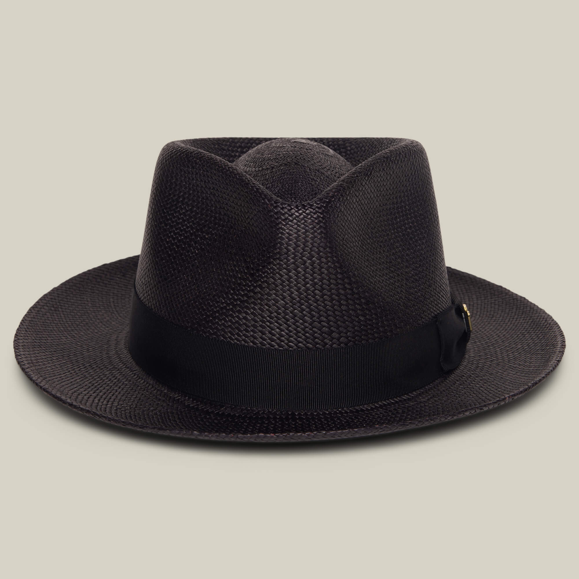 The Goorin Bros. John Sr. is a dark brown toquilla teardrop fedora with a wide brim and black grosgrain band, offering stylish 50 UPF sun protection, shown on a beige background.