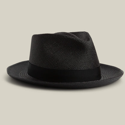 The Goorin Bros. John Sr. is a black toquilla fedora hat with a wide brim and black ribbon band, offering 50 UPF sun protection, displayed on a neutral background.