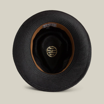The John Sr. by Goorin Bros. is a black woven toquilla fedora with an interior leather band and gold oval label in the crown, viewed from above. Provides 50 UPF sun protection for stylish safety.