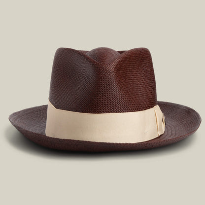 The Goorin Bros. John Sr. is a dark brown toquilla teardrop fedora with a textured finish, wide light beige ribbon, and 50 UPF sun protection, shown against a plain background.