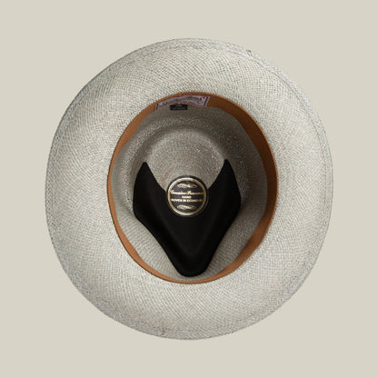 Top view of the John Sr. teardrop fedora hat by Goorin Bros., featuring a light-colored toquilla weave, inner band, black hat holder, and central label highlighting 50 UPF sun protection.