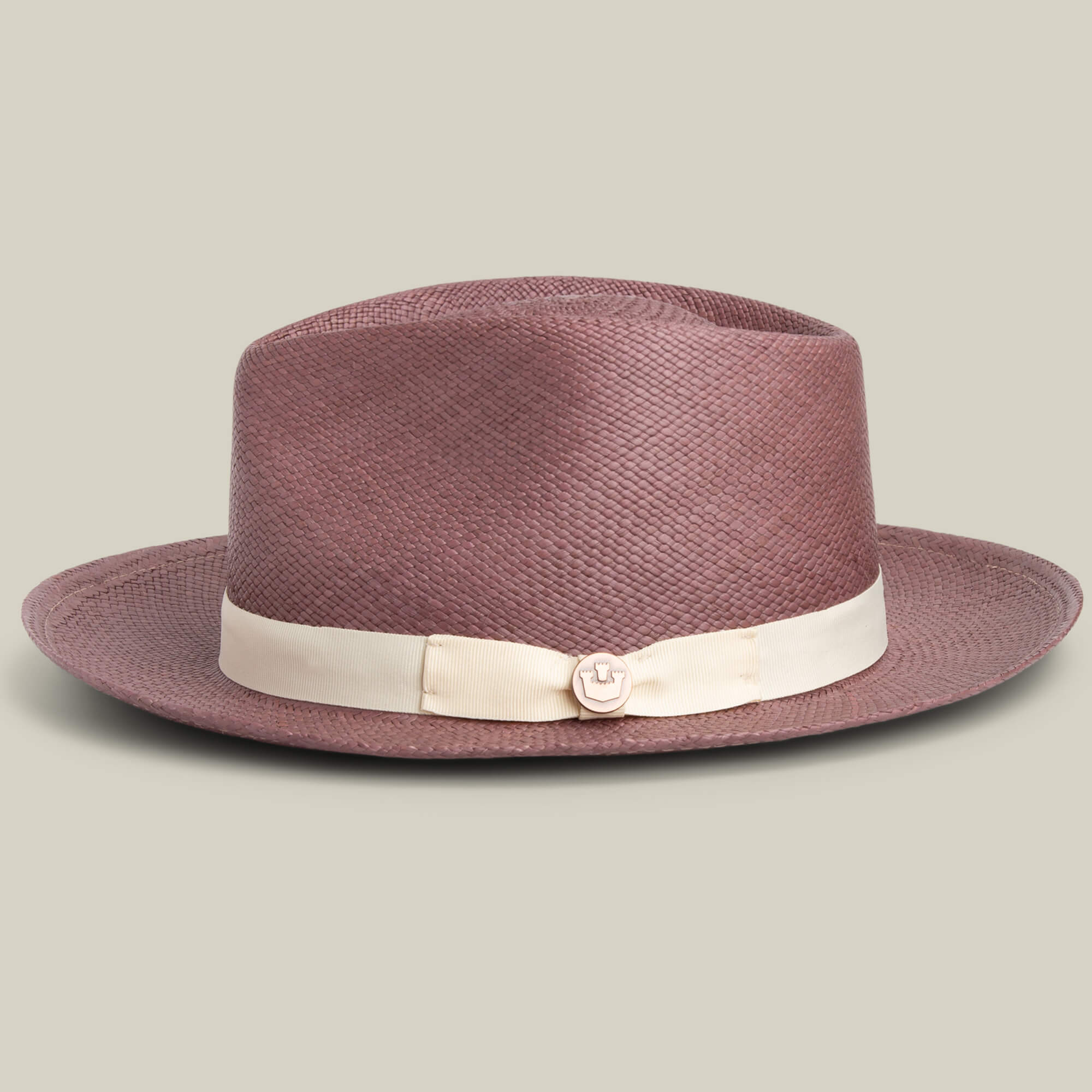 The John Sr. by Goorin Bros. is a mauve toquilla teardrop fedora hat with a wide brim, cream ribbon band, front metal emblem, and 50 UPF sun protection, perfect for stylish outdoor wear.