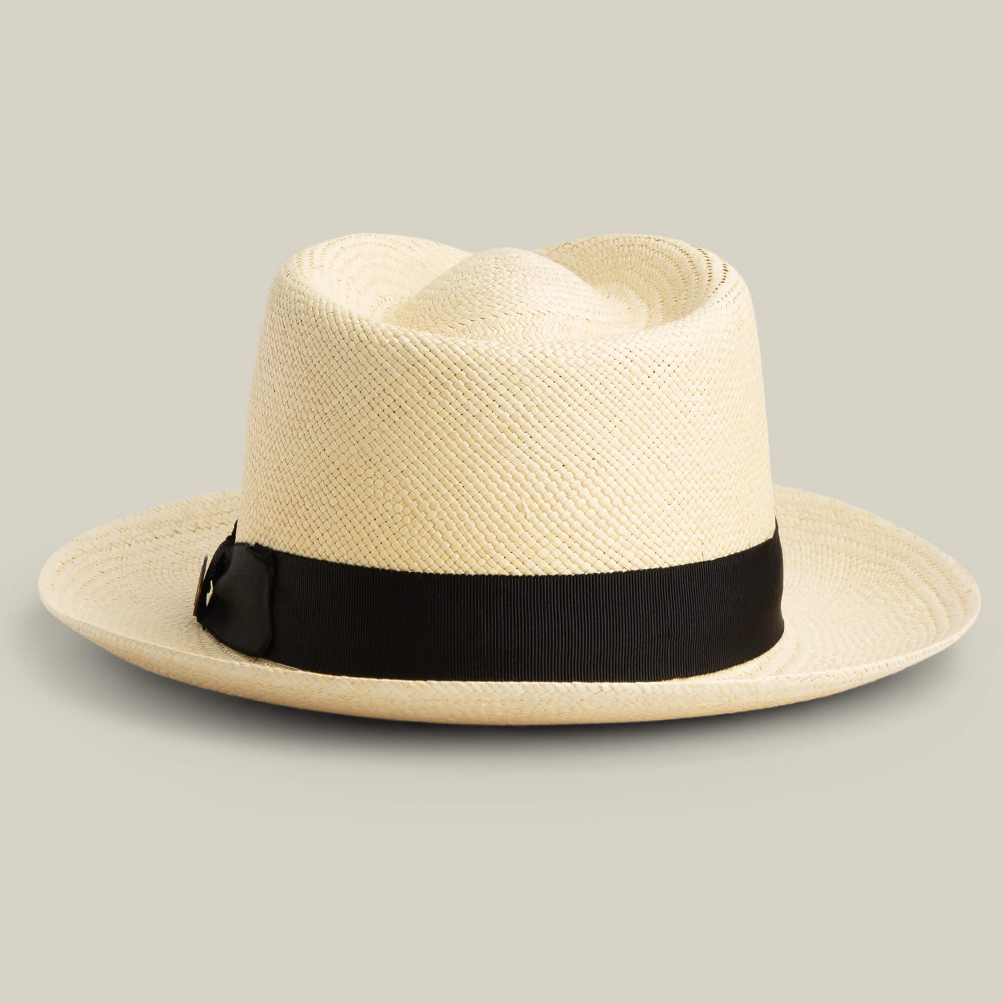The Goorin Bros. John Sr. is a cream toquilla teardrop fedora with a wide brim, black ribbon band, and 50 UPF, offering stylish sun protection against a plain backdrop.