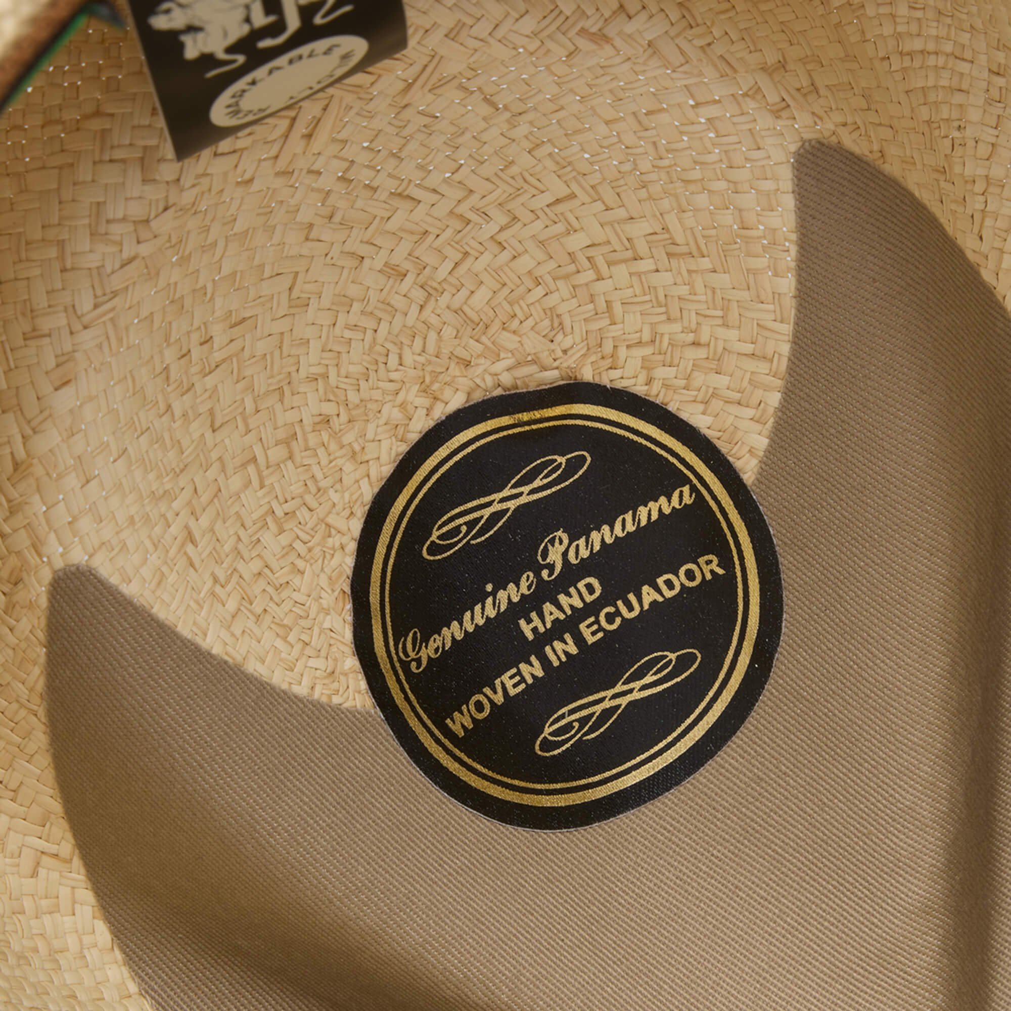 Close-up of the interior of the John Sr. toquilla teardrop fedora by Goorin Bros., featuring a black and gold label reading Genuine Panama Hand Woven in Ecuador and offering UPF 50 sun protection.