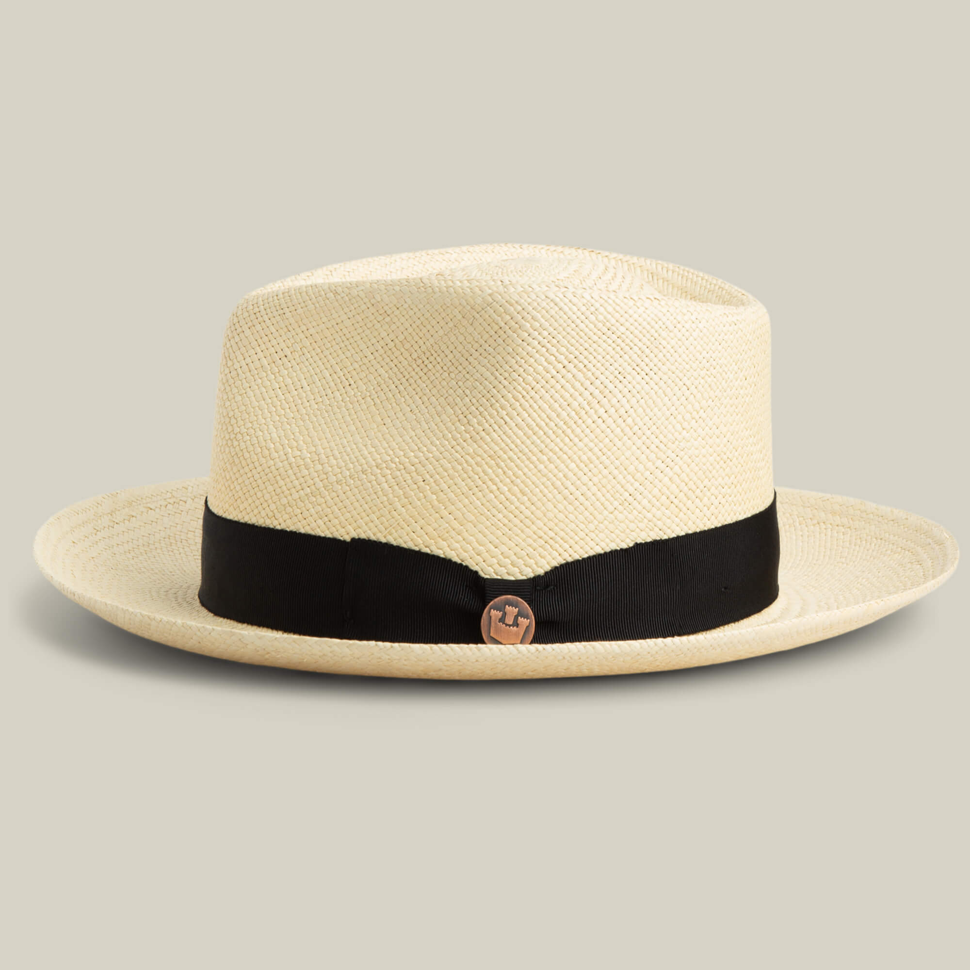 The Goorin Bros. John Sr. fedora is cream-colored with a black band and round metal pin, offering stylish sun protection at 50 UPF, shown against a plain background.