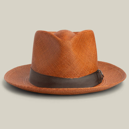 The John Sr. by Goorin Bros. is a brown woven toquilla teardrop fedora with a wide brim, dark brown ribbon band, and 50 UPF sun protection, shown against a neutral background.