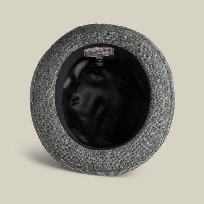 A top-down view of the inside of a grey textured Goorin Bros. Shady Tweed Fedora, featuring a black satin lining and a Moon Mill England label on the inner band.
