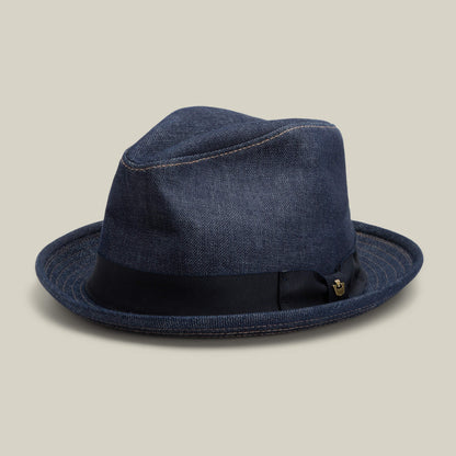 Noisy Big Stepper by Goorin Bros.—a dark blue denim fedora made from premium cone denim, finished with a black ribbon band and visible stitching—displayed on a neutral background.