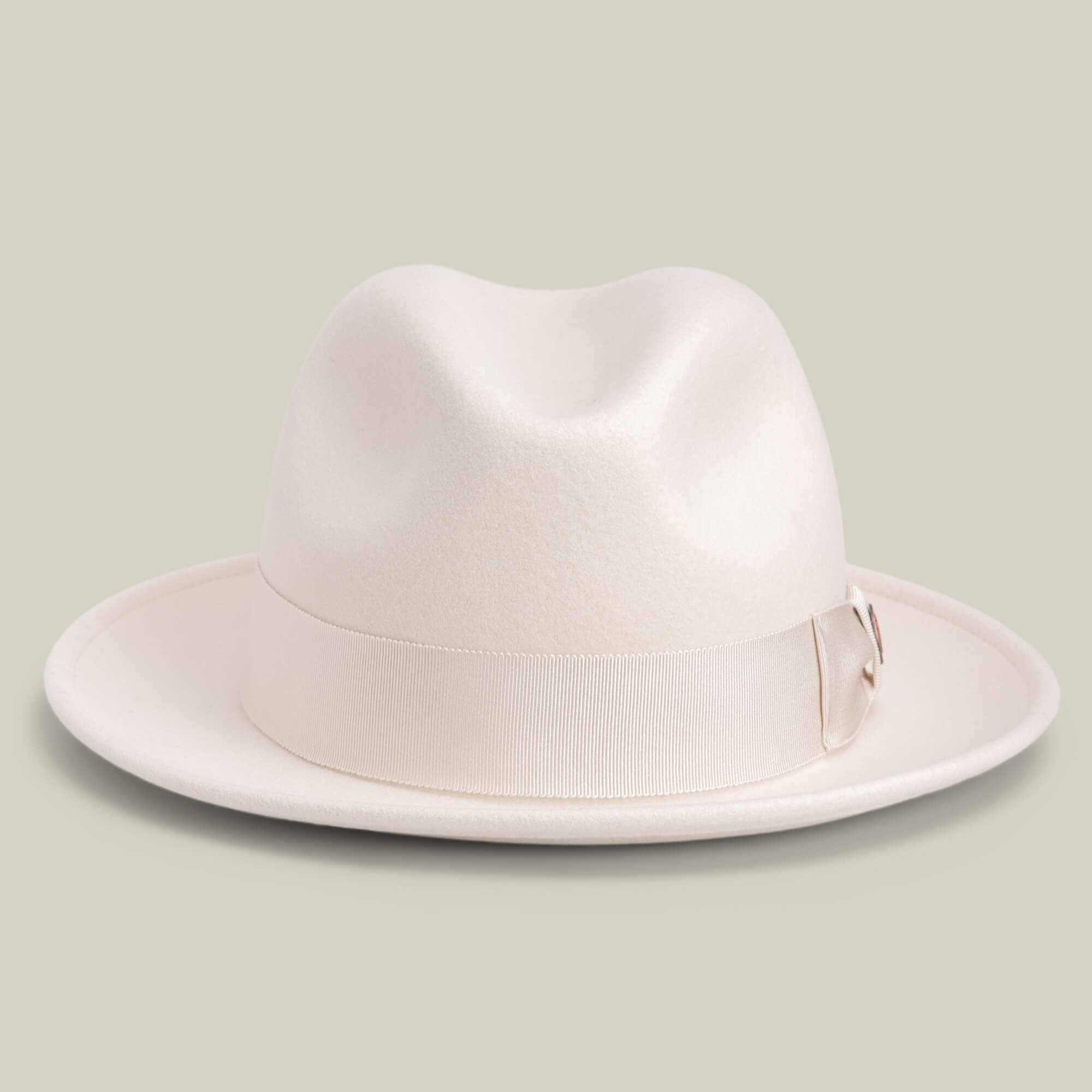 Dean the Butcher by Goorin Bros. is a cream-colored, American-made fedora with a wide brim and matching grosgrain hatband, shown against a plain light background.