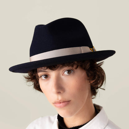 A person with short brown hair wears the Goorin Bros. "Dean the Butcher" fedora, featuring a German wicking sweatband and light band, paired with a white collared shirt, looking directly at the camera against a plain background.