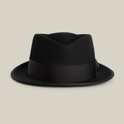 The Goorin Bros. Slick Carter is a black felt fedora hat with a wide ribbon band and short wool brim, inspired by Slick Carter’s effortless style, shown against a plain beige background.