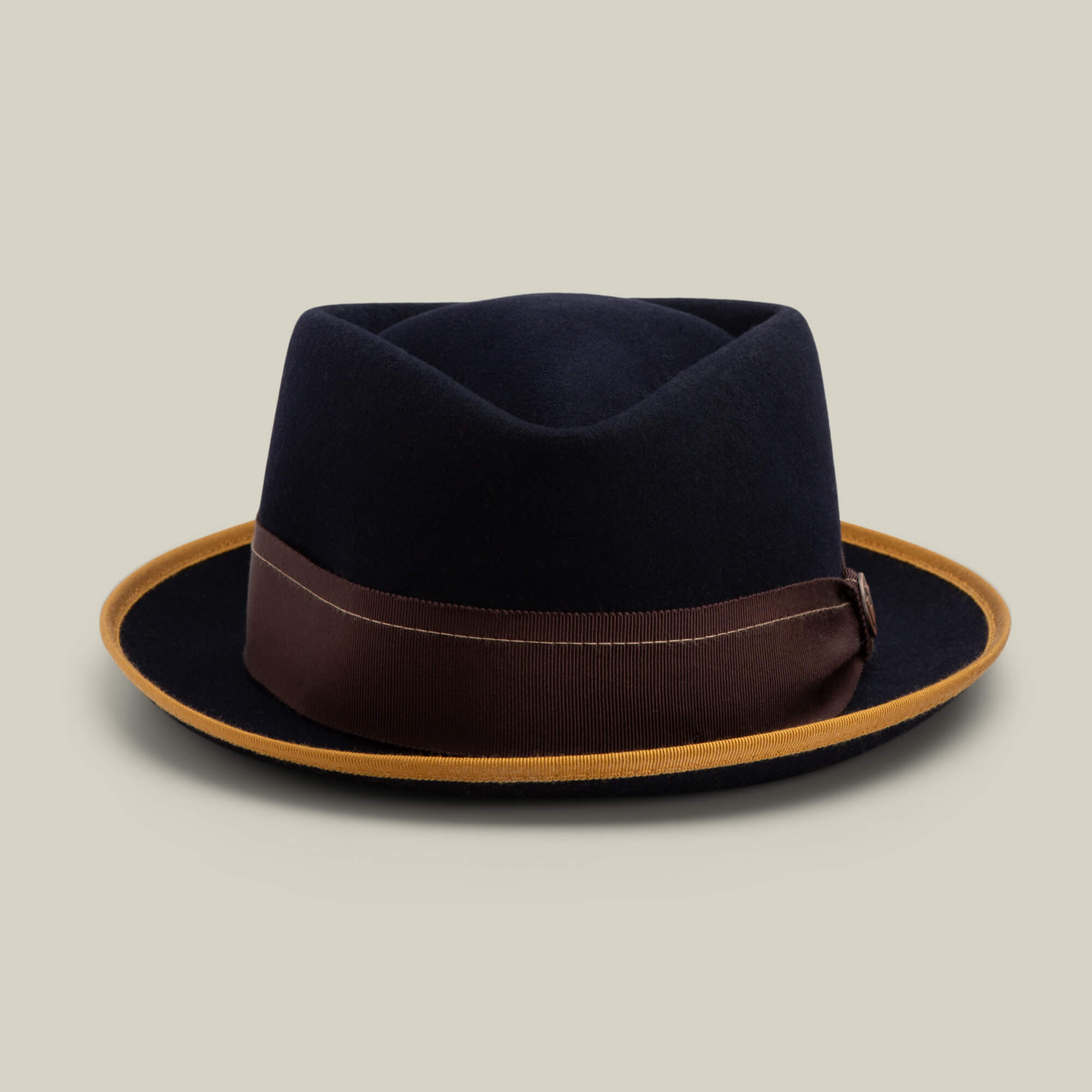 The Goorin Bros. Slick Carter is a black wool short brim fedora featuring a brown ribbon band and tan brim edge, shown on a plain light background—ideal for achieving timeless style.
