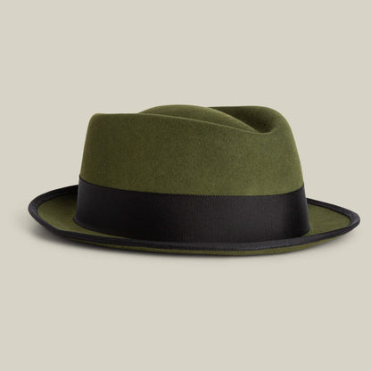 The Slick Carter by Goorin Bros. is an olive green wool short brim fedora with a wide black band, shown on a plain beige background—ideal for effortlessly elevating your style.