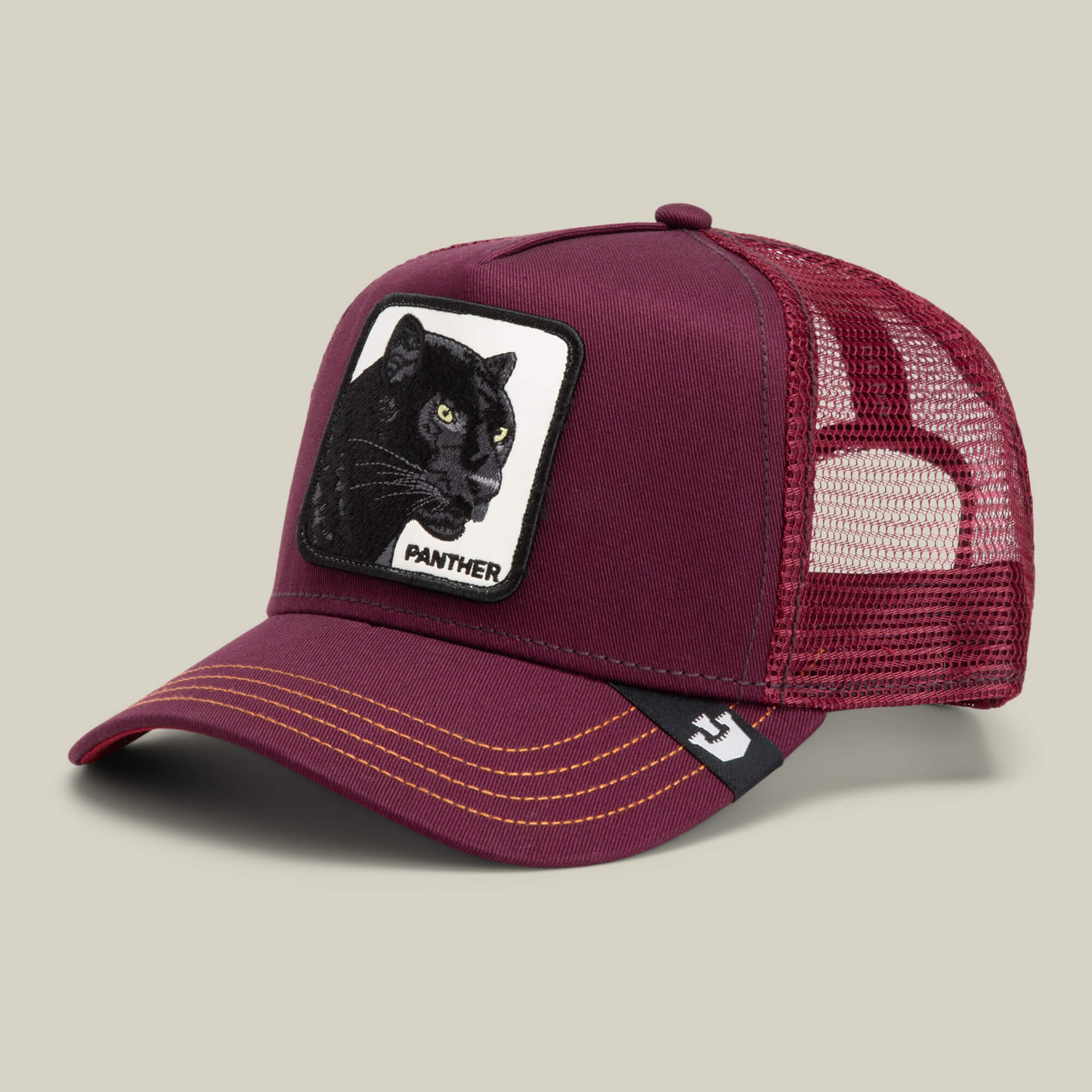 The Panther by Goorin Bros. is a maroon trucker baseball hat with yellow stitching and a front patch featuring a black panther illustration and the word PANTHER, part of The Farm collection.