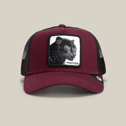 The Panther by Goorin Bros. is a burgundy trucker baseball hat with a mesh back and a front patch showing an embroidered black panther and “PANTHER” in capitals—ideal for fans of The Farm style.