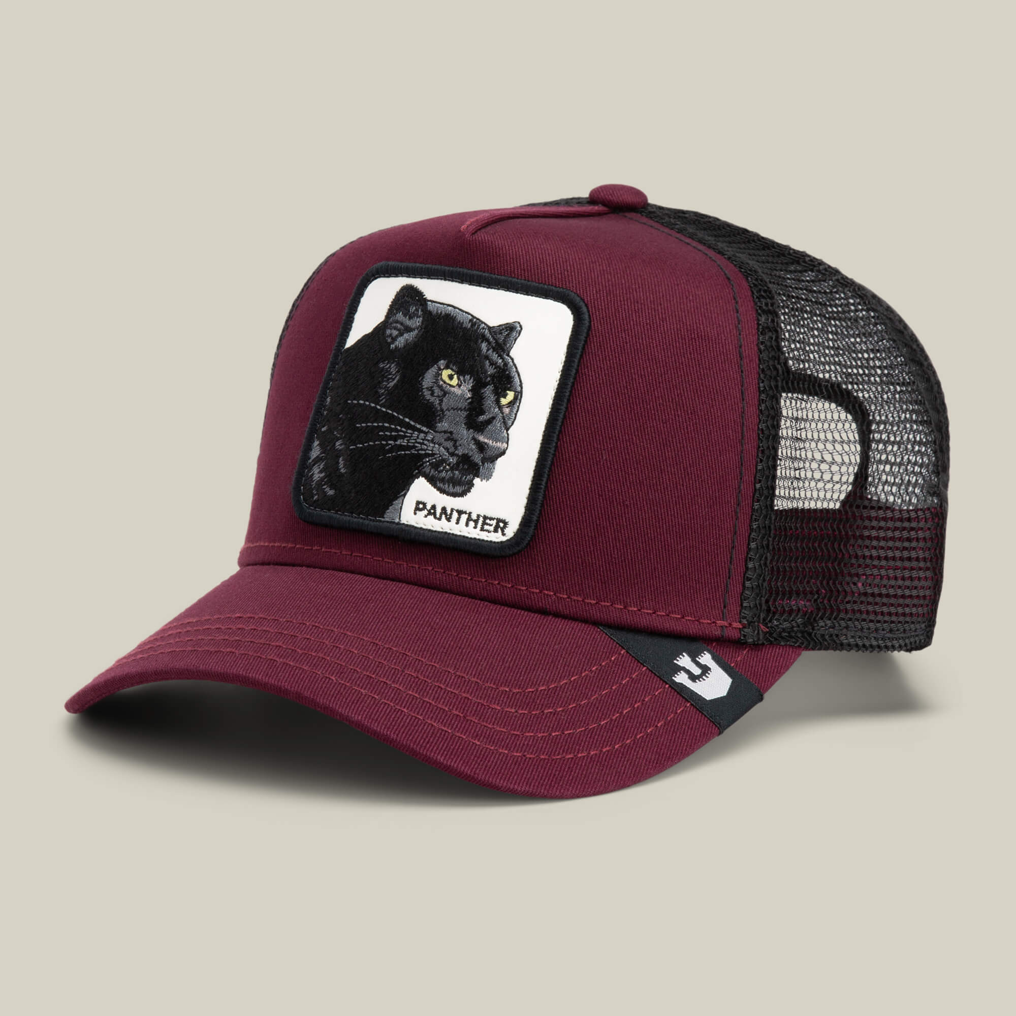 The Panther by Goorin Bros. is a maroon and black trucker baseball hat with a mesh back and a front patch featuring an embroidered black panther and the word "PANTHER.