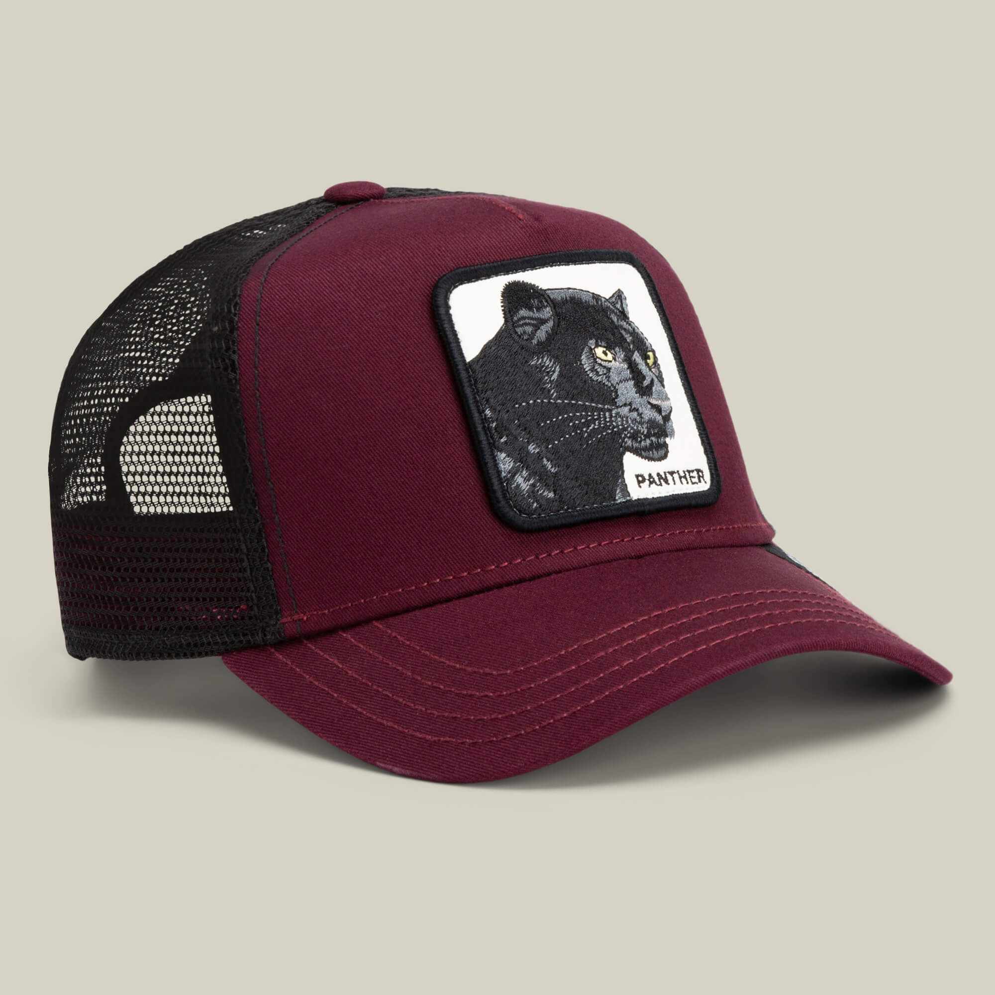 The Panther by Goorin Bros. is a maroon and black trucker hat with mesh panels, featuring an embroidered black panther patch and the word PANTHER—an eye-catching addition to your Ninja Kitten or The Farm collection.