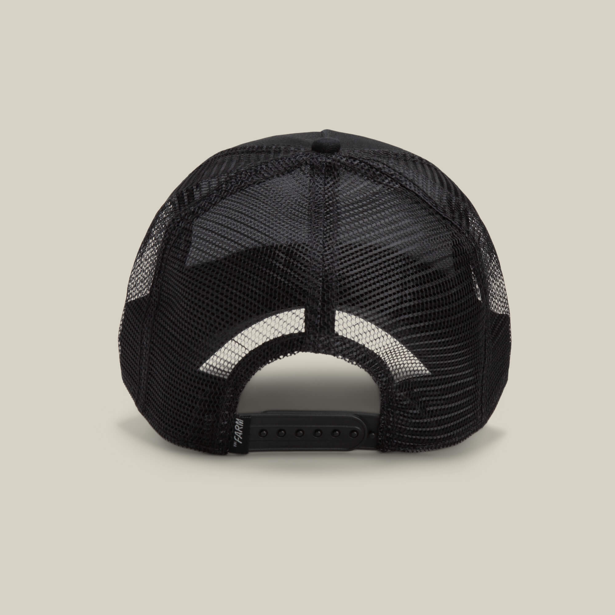 The Freedom Eagle by The Farm—black mesh trucker hat shown from the back, featuring an adjustable snapback closure on a plain beige background for cool, stylish comfort outdoors.