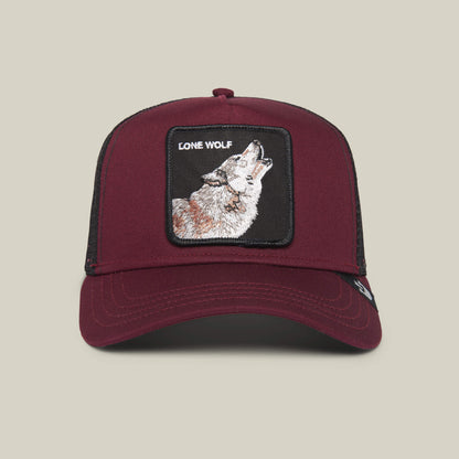 The Farm’s “The Lone Wolf” maroon trucker hat features a black mesh back and a front patch with a howling wolf and LONE WOLF text—ideal for the independent spirit.