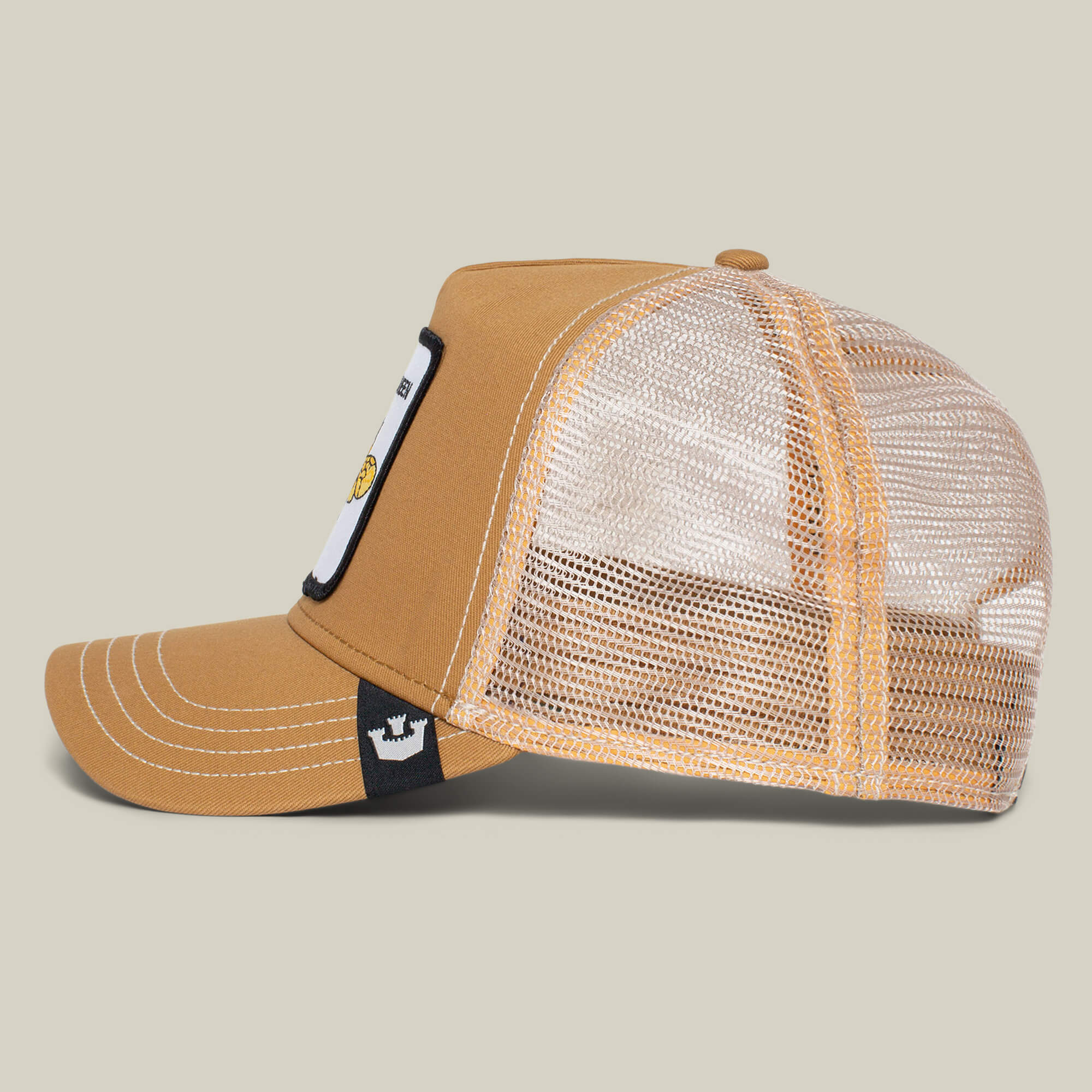 Side view of The Farm’s “The Queen Bee” brown and beige mesh trucker hat with flat bill, white stitching, front patch, and adjustable snapback—slay your style and wear your crown with confidence.
