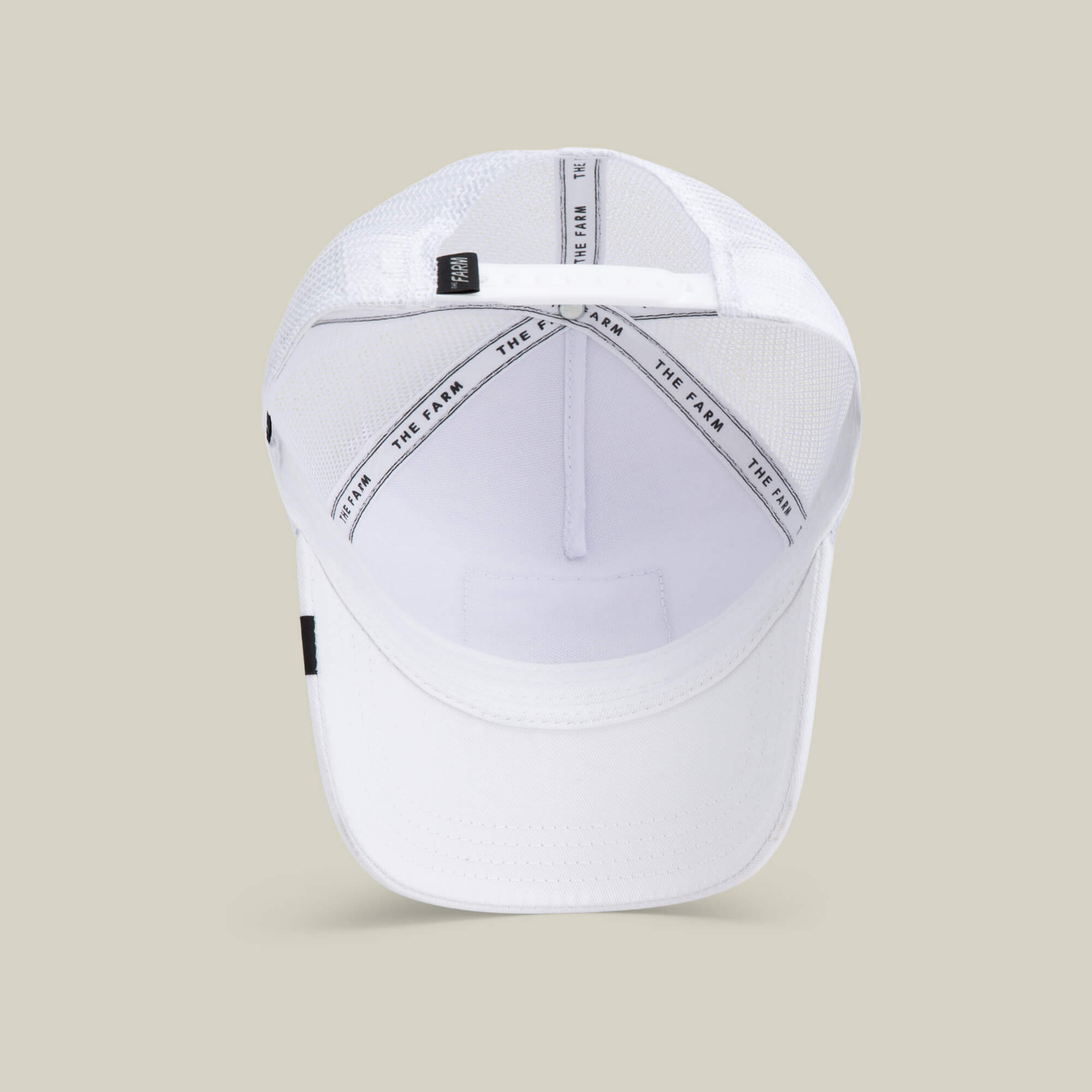 The Queen Bee baseball cap by The Farm is shown from above, highlighting its mesh back panels, interior sweatband, and branded crown taping with THE FARM text—an effortless style statement.